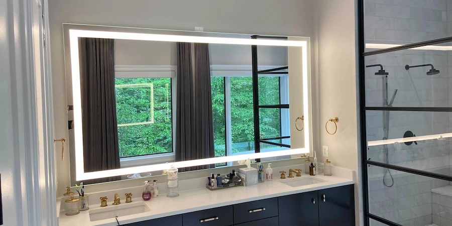 illuminated bathroom mirror with a bright, cool color temperature above a double vanity.